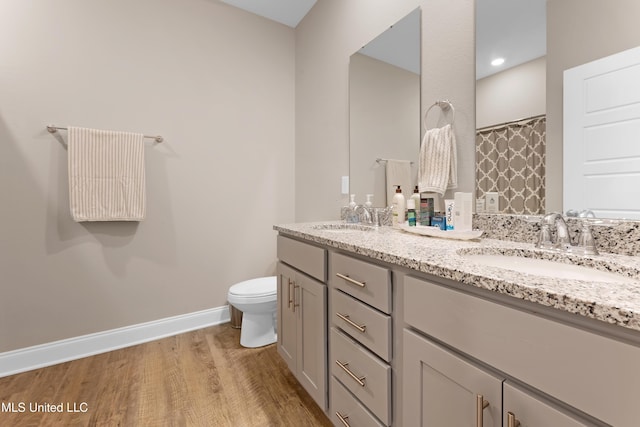 19489 Little Manatee St, Biloxi, MS 39532 - bathroom with double vanity, wood finished floors, toilet, and baseboards