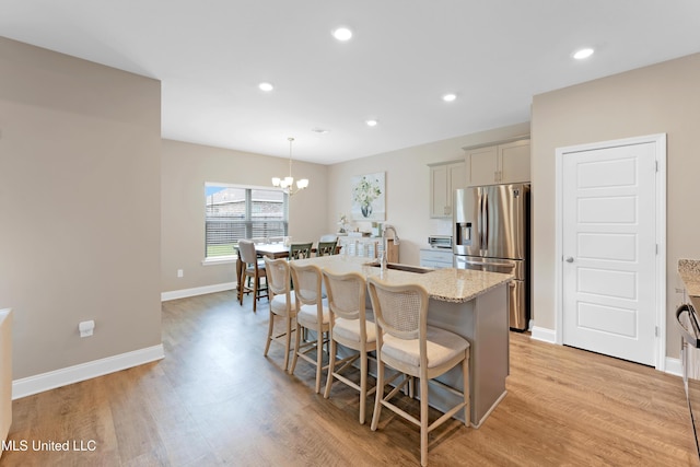19489 Little Manatee St, Biloxi, MS 39532 - kitchen with stainless steel fridge, a sink, light wood finished floors, a center island with sink, and recessed lighting
