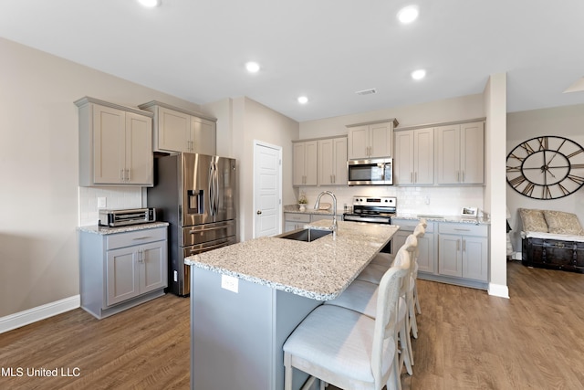 19489 Little Manatee St, Biloxi, MS 39532 - kitchen featuring appliances with stainless steel finishes, gray cabinetry, a sink, wood finished floors, and recessed lighting