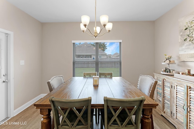 19489 Little Manatee St, Biloxi, MS 39532 - dining room featuring light wood-style flooring, a chandelier, and baseboards