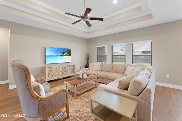 19489 Little Manatee St, Biloxi, MS 39532 - living area featuring a tray ceiling, baseboards, ornamental molding, a ceiling fan, and light wood-type flooring