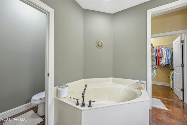 bathroom with toilet, a bathing tub, and hardwood / wood-style flooring