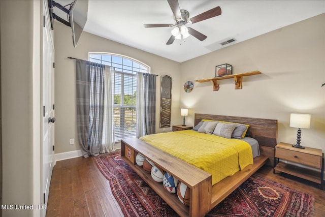 bedroom featuring multiple windows, dark wood-type flooring, and ceiling fan