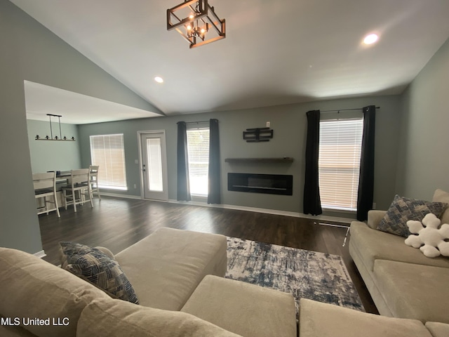 living room featuring a glass covered fireplace, lofted ceiling, wood finished floors, a notable chandelier, and recessed lighting