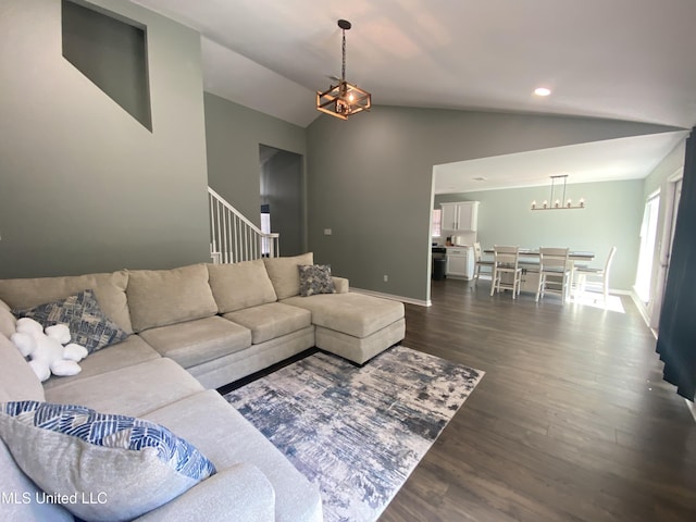 living room featuring baseboards, dark wood-type flooring, stairs, vaulted ceiling, and a chandelier