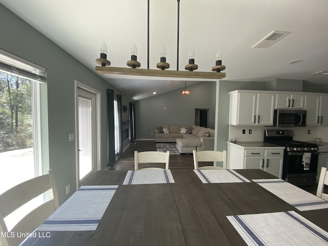 dining area with visible vents, vaulted ceiling, and dark wood-style flooring