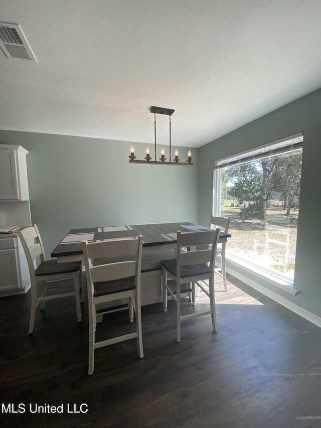 dining space featuring a chandelier, visible vents, and dark wood finished floors