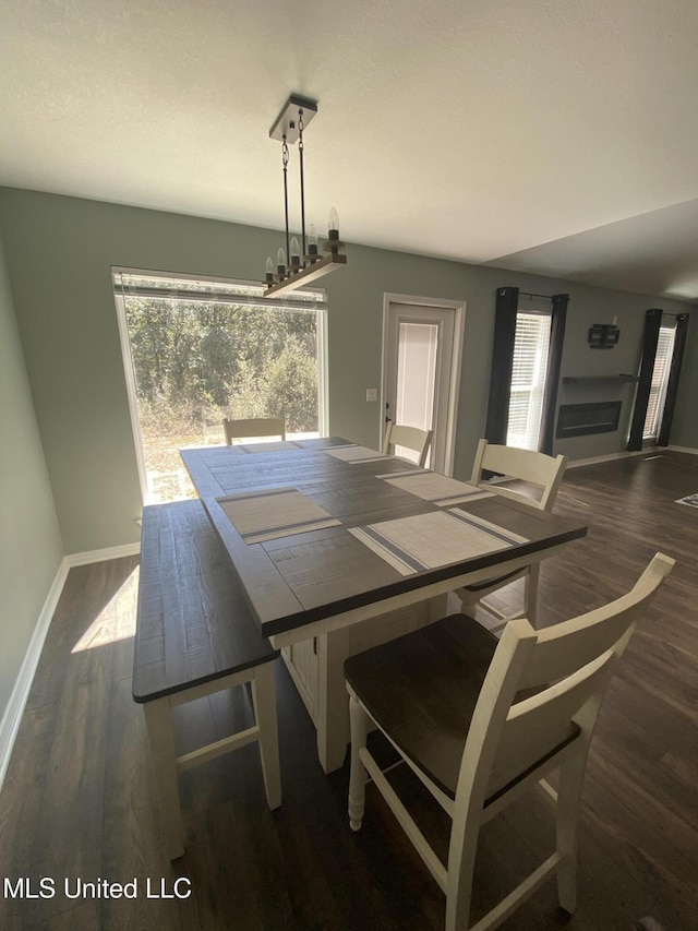 dining room featuring a wealth of natural light, wood finished floors, and an inviting chandelier