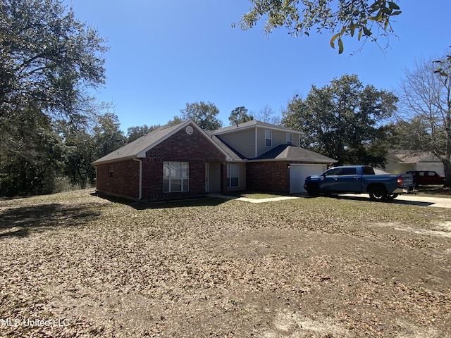 view of front of property featuring an attached garage and brick siding