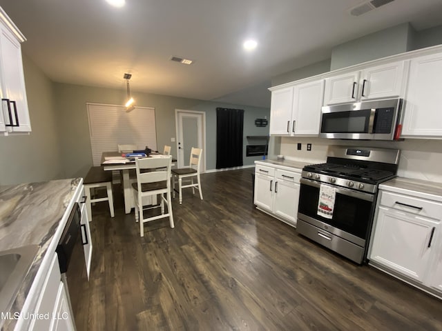 kitchen featuring appliances with stainless steel finishes, white cabinets, visible vents, and dark wood-type flooring