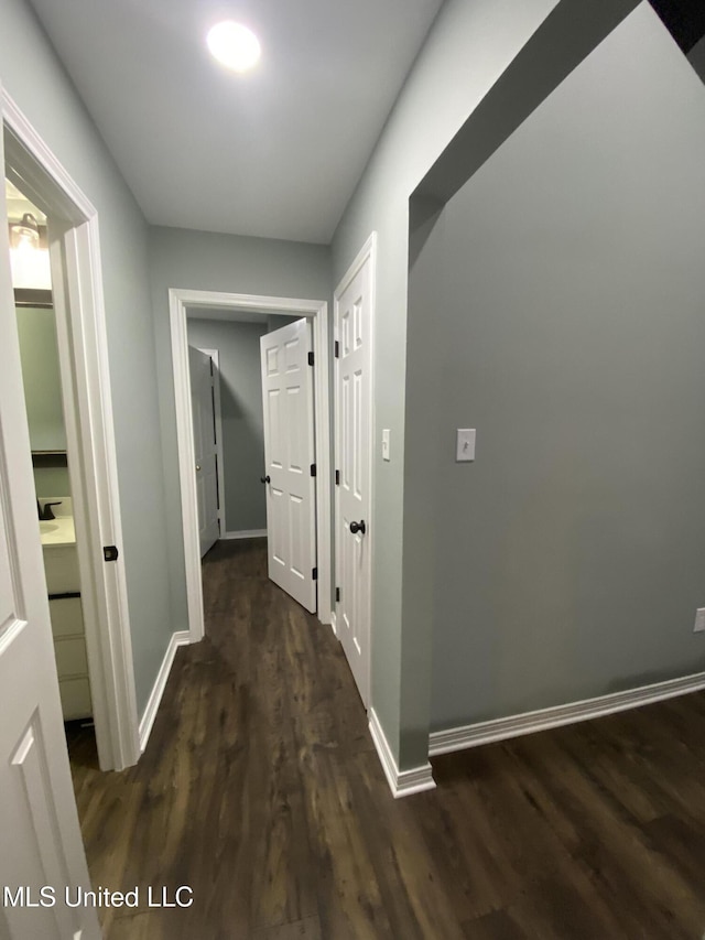 hallway with baseboards and wood finished floors