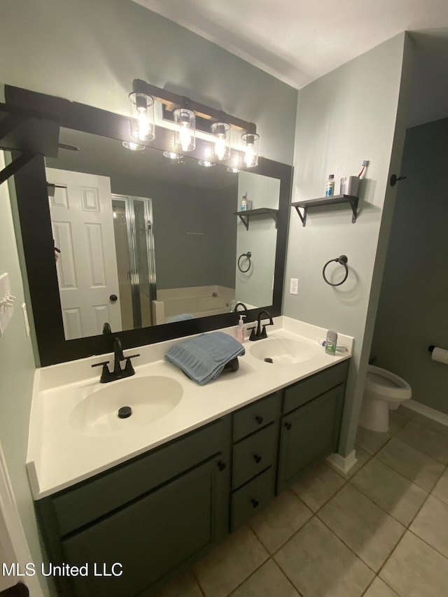 bathroom with a garden tub, a stall shower, a sink, and tile patterned floors