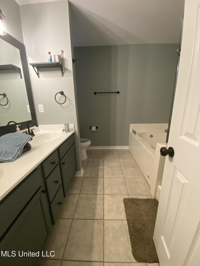 bathroom featuring tile patterned flooring, toilet, a sink, a bath, and double vanity