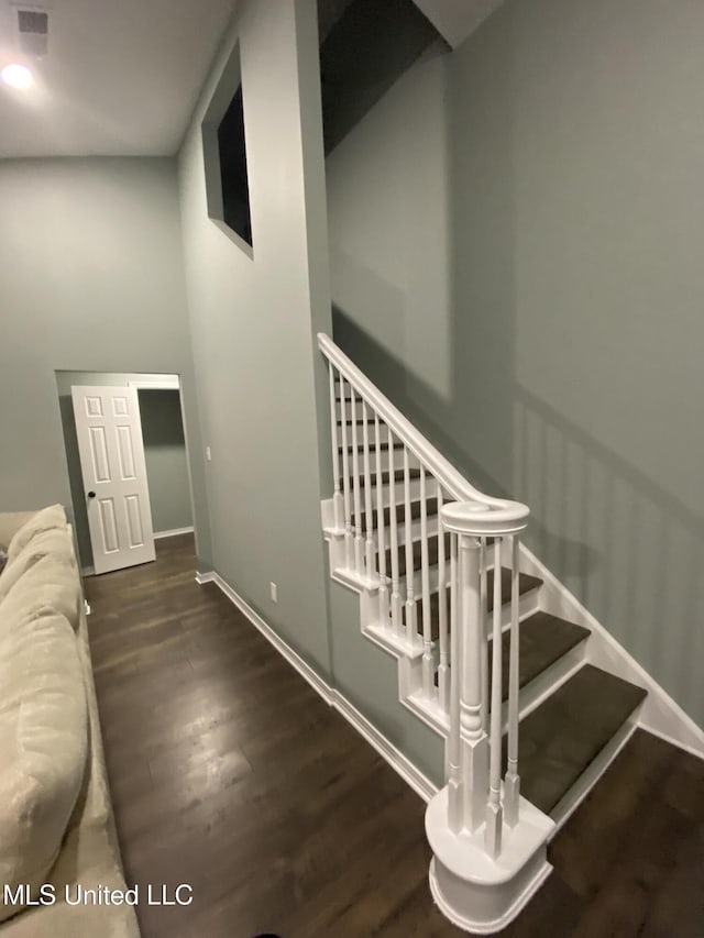 staircase featuring baseboards and wood finished floors