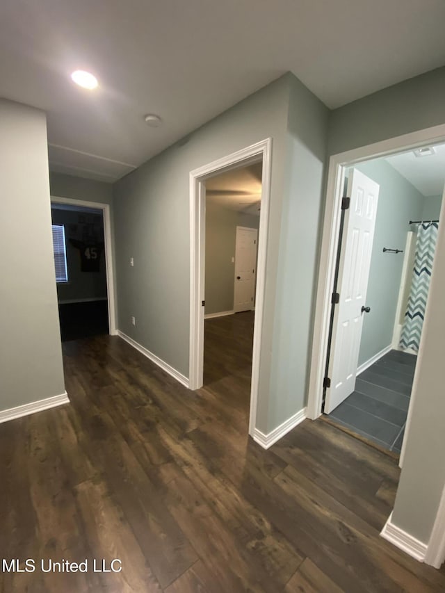 hallway with dark wood-style floors, recessed lighting, and baseboards