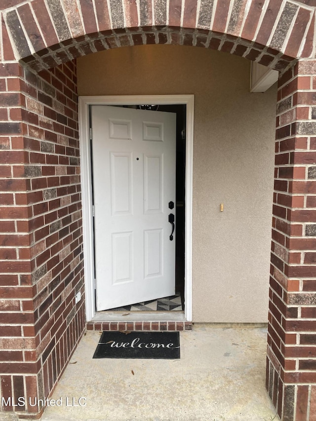 entrance to property featuring brick siding