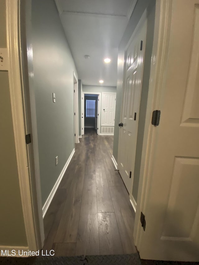 hall with dark wood-style flooring and baseboards