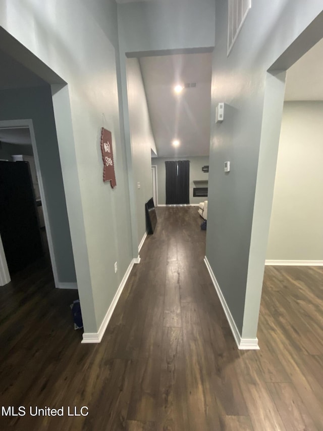 hallway with dark wood-style floors and baseboards