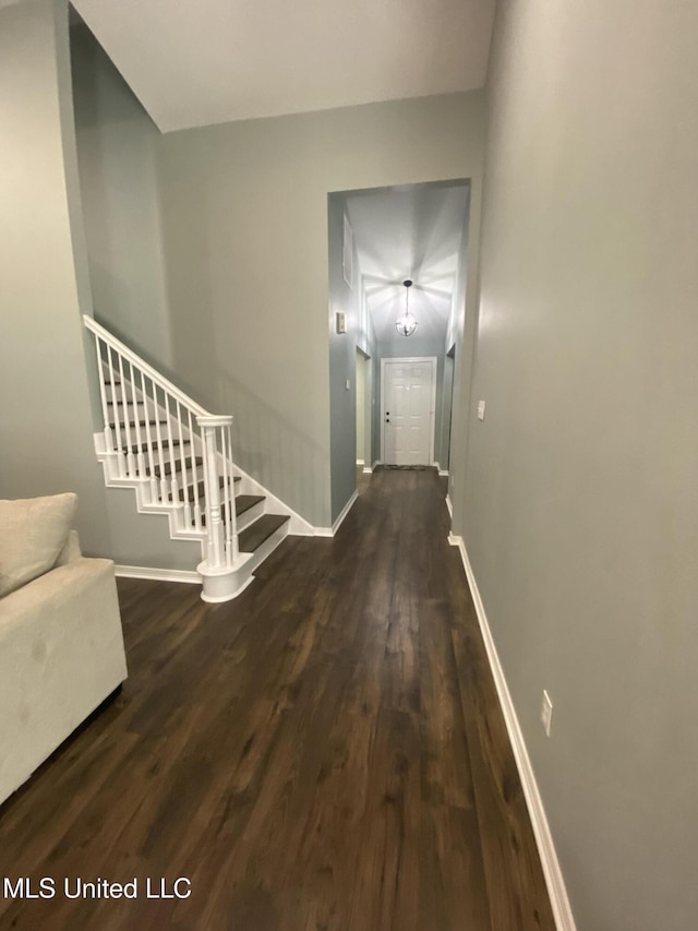 hallway with stairs, baseboards, and wood finished floors