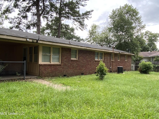 view of side of home with crawl space, a yard, and brick siding