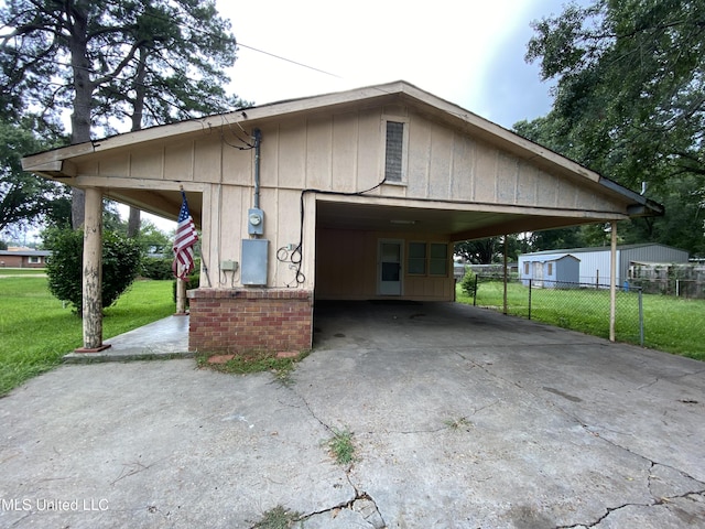 view of property exterior featuring a yard, fence, and driveway