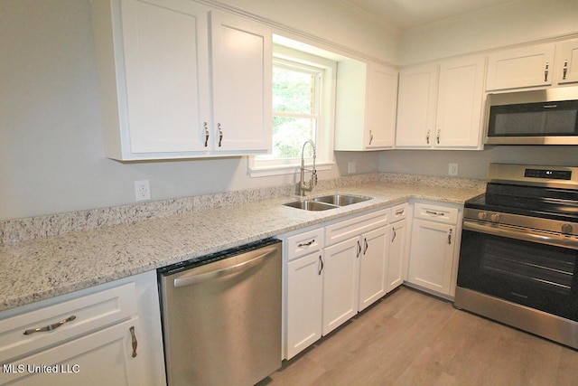 136 Childress Rd, Lucedale, MS 39452 - kitchen featuring appliances with stainless steel finishes, a sink, light wood-style floors, and white cabinetry