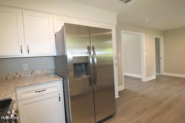 136 Childress Rd, Lucedale, MS 39452 - kitchen featuring appliances with stainless steel finishes, white cabinets, baseboards, light wood-type flooring, and light stone counters