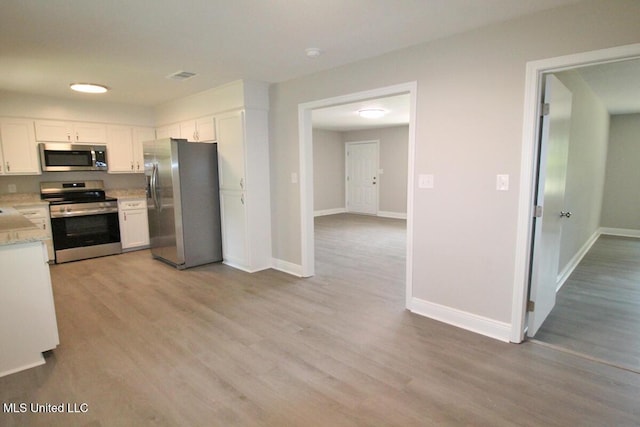 136 Childress Rd, Lucedale, MS 39452 - kitchen with appliances with stainless steel finishes, white cabinets, light wood-type flooring, and baseboards