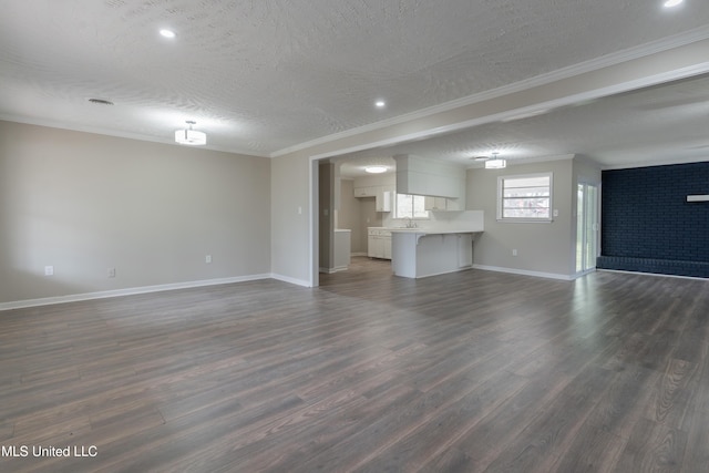 unfurnished living room featuring ornamental molding, a textured ceiling, and dark wood-style flooring