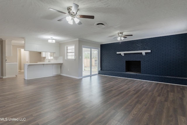 unfurnished living room featuring dark wood finished floors, ceiling fan, a fireplace, and a textured ceiling