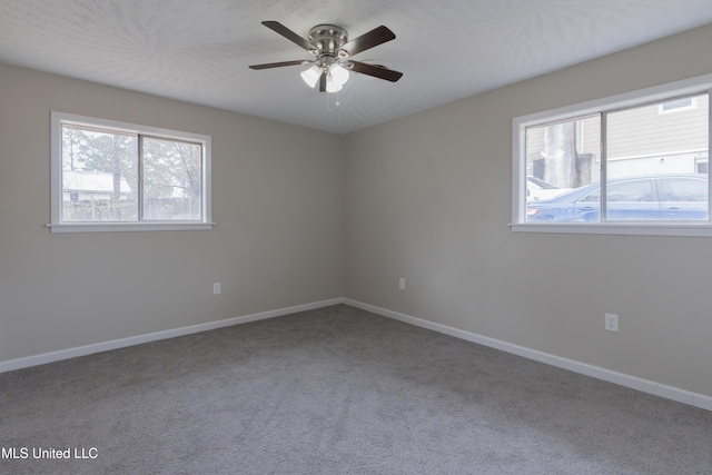 empty room with carpet flooring, ceiling fan, and baseboards