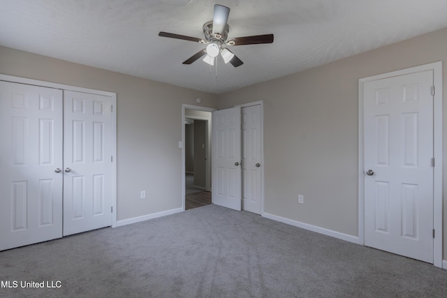 unfurnished bedroom with ceiling fan, two closets, baseboards, and carpet floors