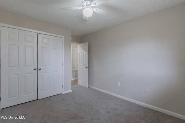 unfurnished bedroom featuring a textured ceiling, a closet, carpet floors, baseboards, and ceiling fan