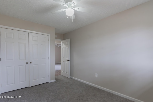 unfurnished bedroom featuring a ceiling fan, a textured ceiling, a closet, carpet, and baseboards