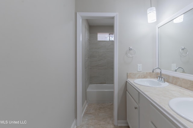 bathroom with double vanity, baseboards, and a sink