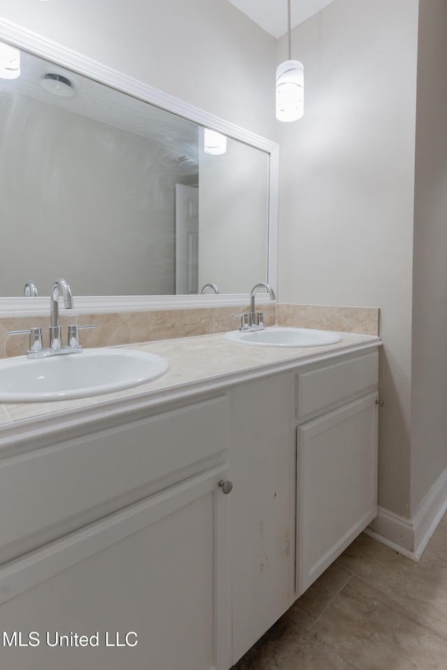 full bath with a sink, double vanity, and tile patterned flooring