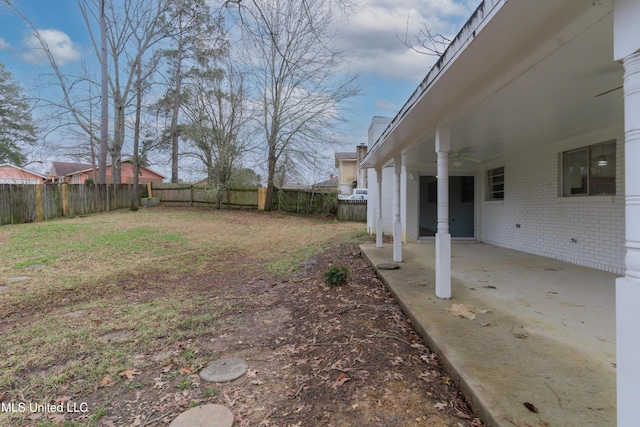 view of yard with a fenced backyard, ceiling fan, and a patio area