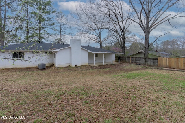 view of yard with central AC and fence