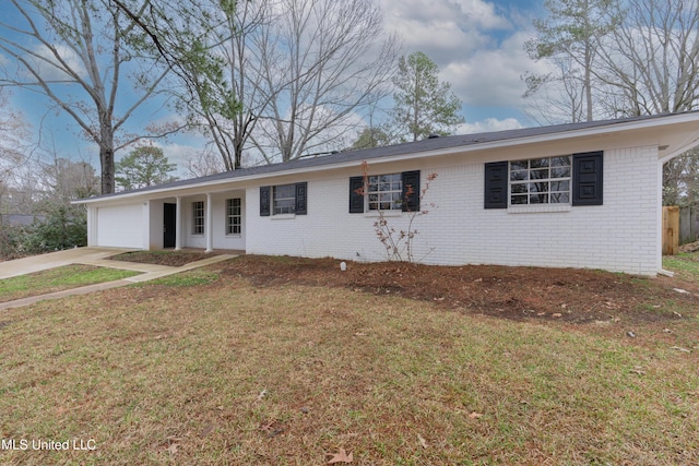 ranch-style home featuring a front yard, concrete driveway, brick siding, and a garage