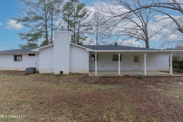 back of house featuring a patio, cooling unit, a ceiling fan, a chimney, and brick siding