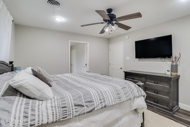 bedroom with dark hardwood / wood-style floors and ceiling fan