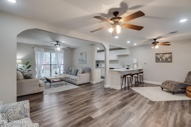 living room with ceiling fan, sink, and dark hardwood / wood-style flooring