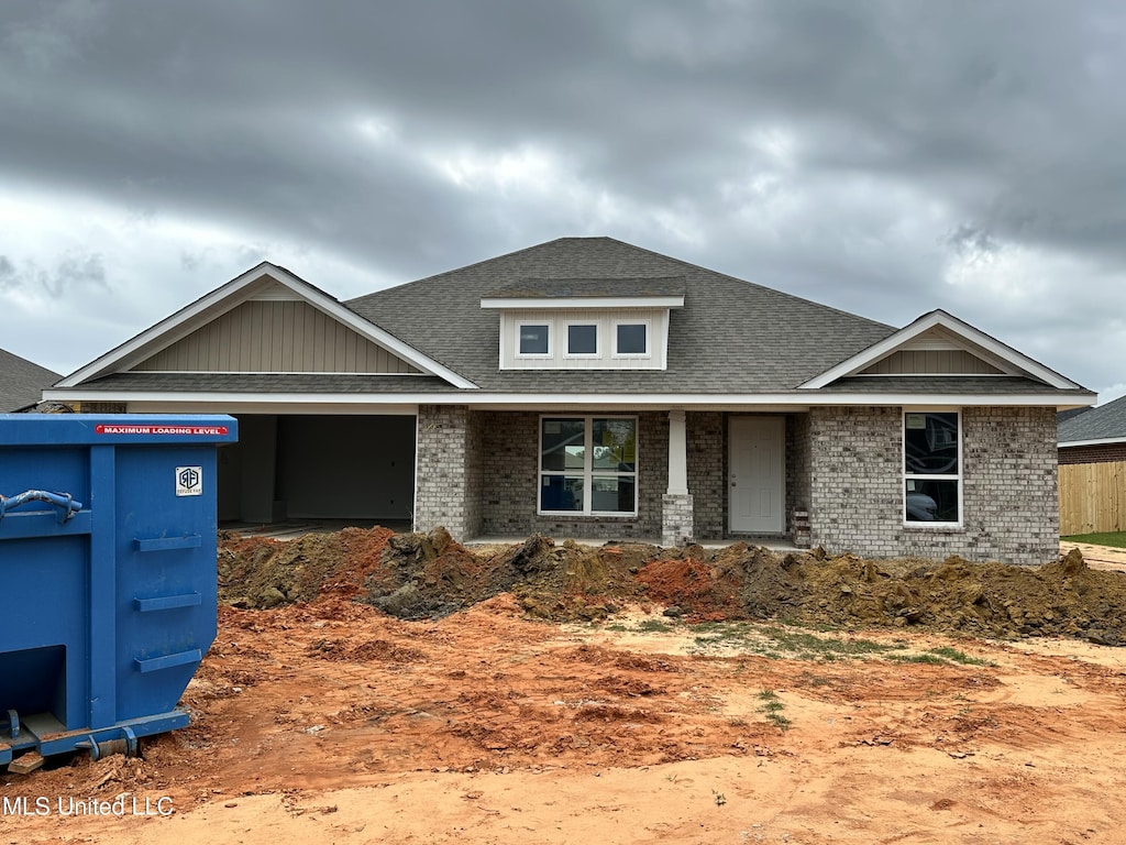 view of front of house with brick siding, an attached garage, and a shingled roof