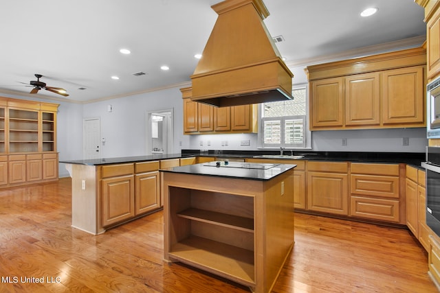 kitchen featuring light hardwood / wood-style floors, premium range hood, ornamental molding, and a center island