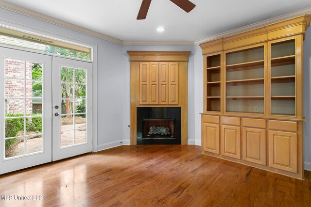 unfurnished living room featuring ornamental molding, french doors, light wood-type flooring, and ceiling fan