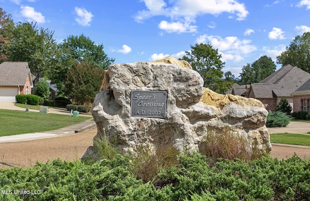 community sign featuring a yard