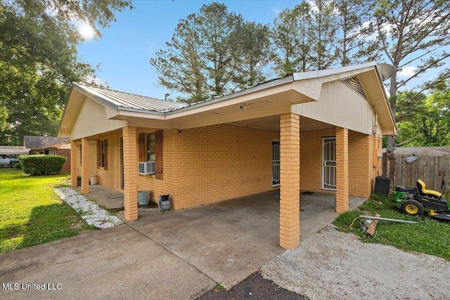 791 Leach St, Yazoo City, MS 39194 - view of property exterior with brick siding, a carport, metal roof, and driveway