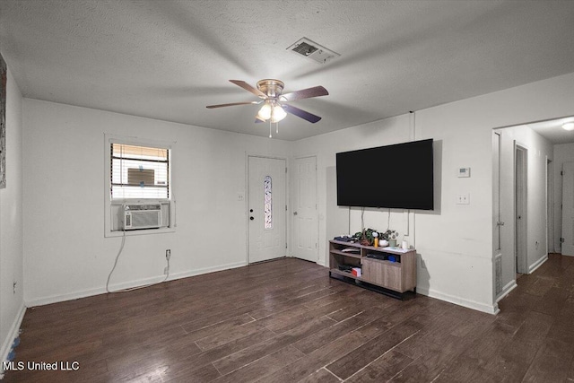 791 Leach St, Yazoo City, MS 39194 - living area featuring cooling unit, ceiling fan, dark wood-type flooring, baseboards, and a textured ceiling