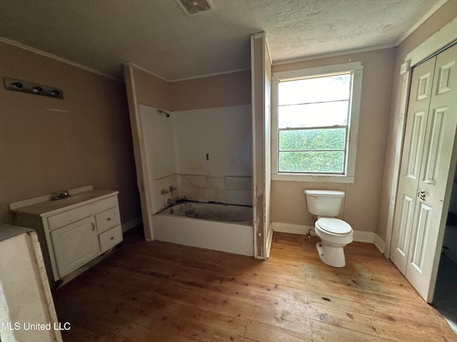 bathroom featuring crown molding, wood-type flooring, toilet, and a tub