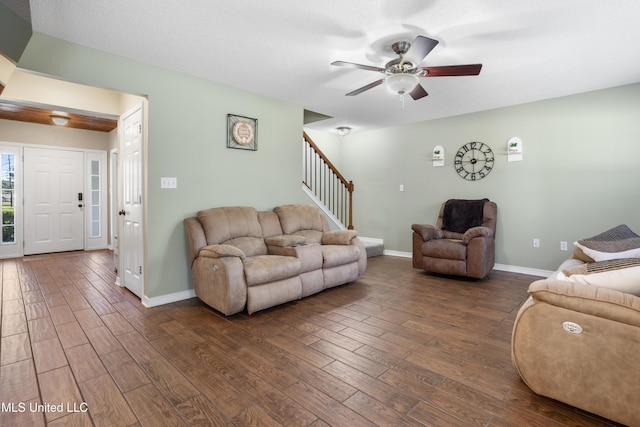 living room featuring a textured ceiling, ceiling fan, and dark hardwood / wood-style floors